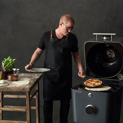 sfeerbeeld van de Everdure 4K met een staande Heston Blumenthal die een pizzabakt in het graphite te koop bij My Cool Kitchen